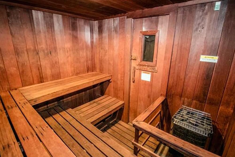 A wooden sauna interior with benches and a small window.