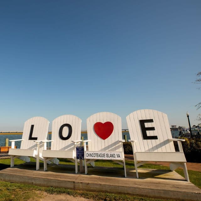 Adirondack chairs form the word "LOVE" with a heart on Chincoteague Island, Virginia.