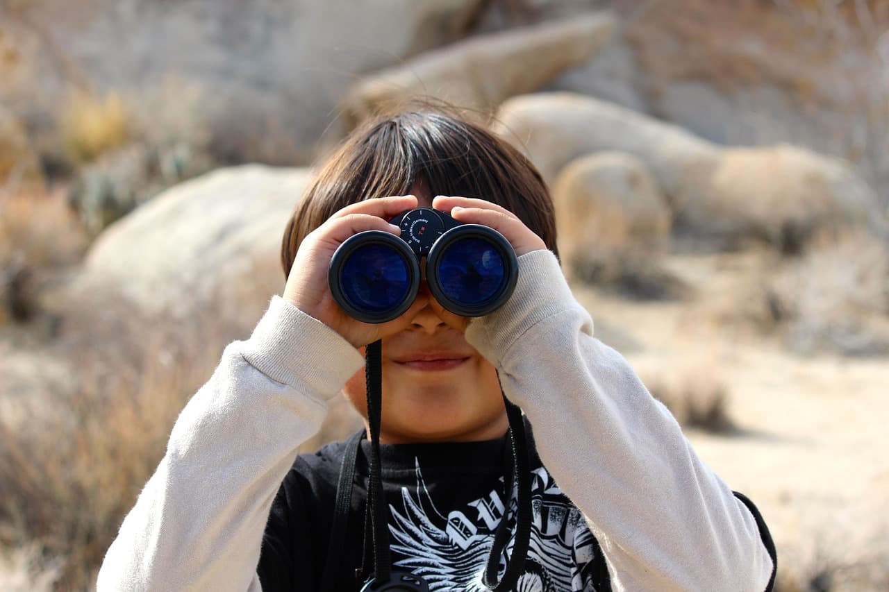 Child with binoculars looking at the camera and smiling Child with binoculars looking at the camera and smiling